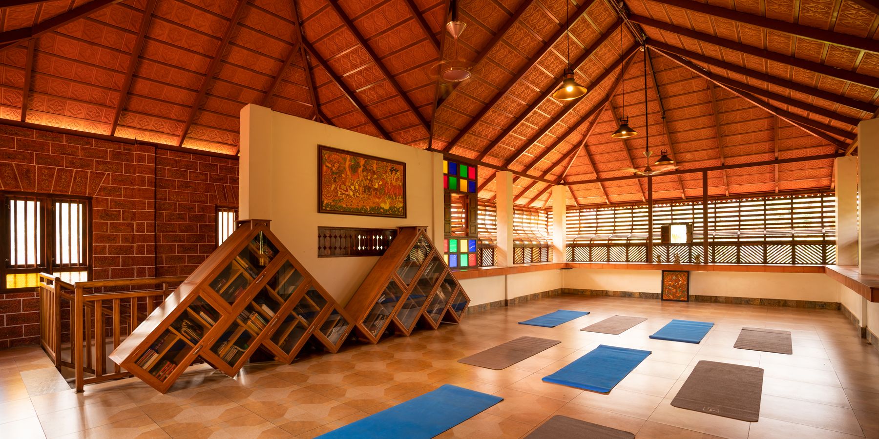 The yoga hall at Neelambari, mats laid out on the floor under a high peaked roof of terracotta tiles and timber.