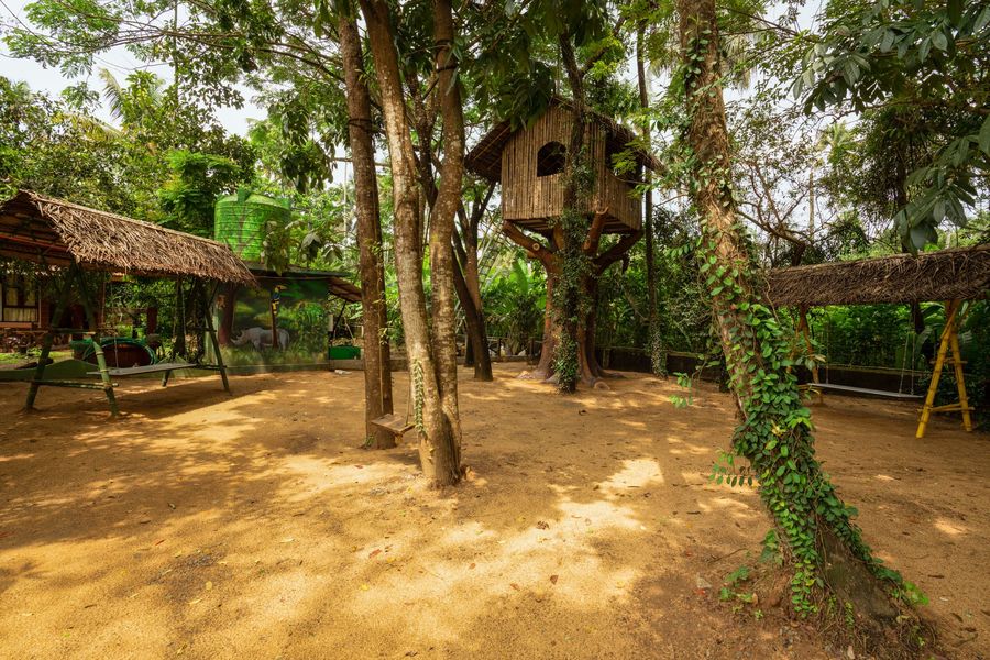 The grounds at Neelambari, a treehouse and shaded play area among the trees.